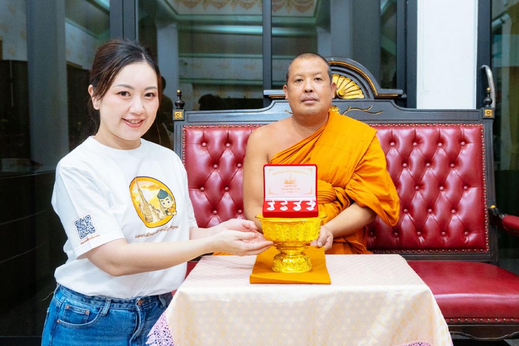 พระครูวินัยธรจีรเดช มอบหรียญสมเด็จพระเจ้าตากสิน รุ่นมหาเศรษฐี แก่ คุณฐนนันท์ ผู้เป็นต้นเสียงในแอปพลิเคชัน แอพเดียวเที่ยวทั่ววัดอรุณ ภาคภาษาจีน